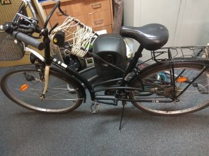 odzyskany rower, za nim stoi reszta przedmiotów, tj. kosiarka i odkurzacz