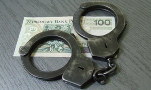 kajdanki leżące na banknocie 100 złotych