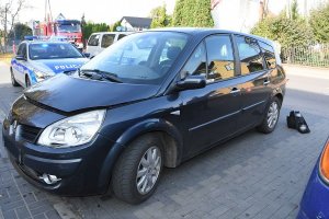 samochód marki renault stojący na parkingu, za nim widoczne dwa radiowozy