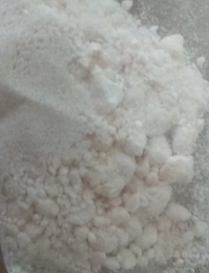 biały proszek wraz z grudkami znajdujący się w woreczku foliowym