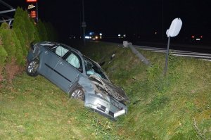 samochód leży w rowie, w tle widać uszkodzoną latarnię