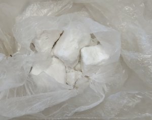 grudki białego proszku leżące na woreczku foliowym