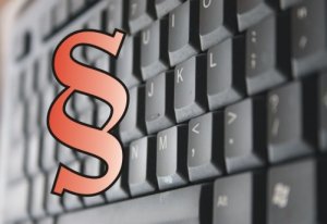 czerwony znak paragrafu, w tle klawiatura laptopa