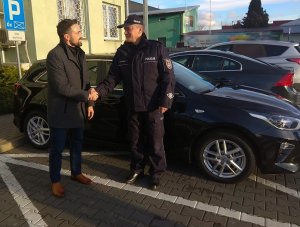 uścisk dłoni Prezydenta Miasta Biała Podlaska oraz Komendanta Miejskiego Policji w Białej Podlaskiej. W tle niezonakowany radiowóz