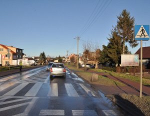 samochód marki Skoda stojący za  przejściem dla pieszych. Po drugiej stronie stoi umundurowany policjant