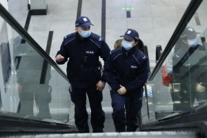 dwoje policjantów stojących na schodach w centrum handlowym