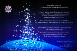 życzenia świąteczne Komendanta Wojewódzkiego Policji w Lublinie. Po lewej stronie choina na niebieskim tle