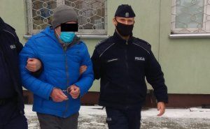 Policjanci wyprowadzają zatrzymanego z Komendy Miejskiej Policji w Białej Podlaskiej.