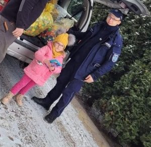 dziecko wraz z opiekunem stojące przy radiowozie