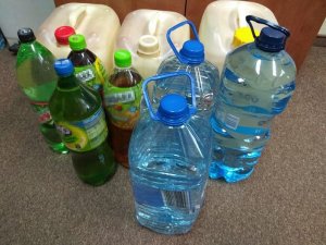 nielegalny alkohol oraz zacier znajdujące się w plastikowych pojemnikach i butelkach