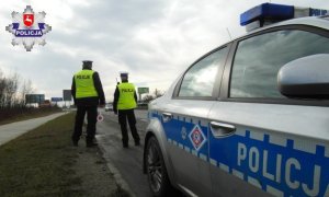 policjanci stojący przy radiowozie