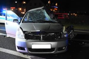 uszkodzony samochód z wybitą szybą stoi na jezdni, za nim w tle radiowóz