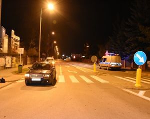 samochód osobowy marki passat stojący na przejściu dla pieszych. Po przeciwnej stronie oznakowany radiowóz