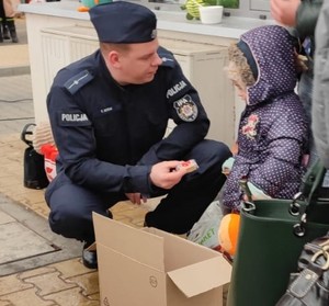 policjant przekazujący dziecku produkty
