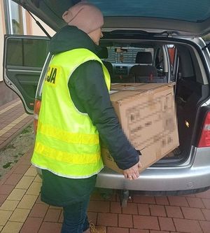 policjantka wkładające pudło do samochodu