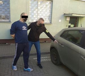 policjant doprowadza mężczyznę do radiowozu