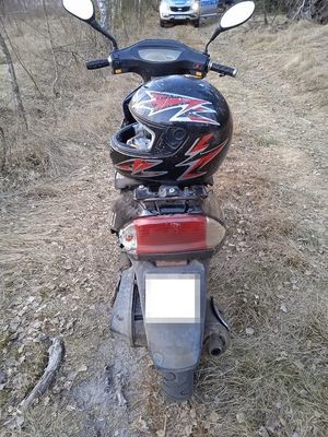 skuter stojący na drodze polnej. W tle widoczny radiowóz