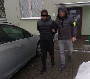 policjant doprowadza mężczyznę do samochodu