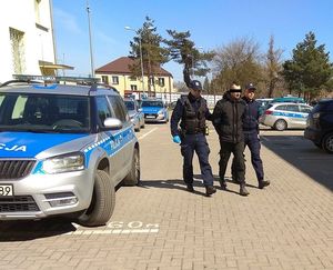 policjanci doprowadzają zatrzymanego mężczyznę