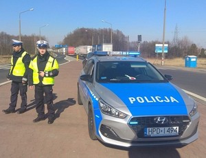 policjanci stojący przy radiowozie
