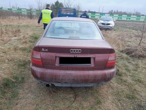 samochód marki Audi. W tle radiowóz i dwaj policjanci