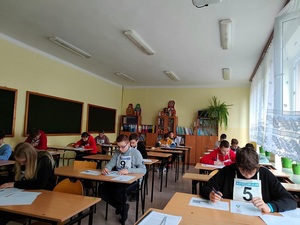 uczniowie siedzą w ławkach podczas testu wiedzy