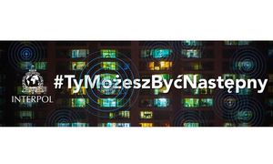 logo Interpolu oraz napis # TYMożeszByćNastępny. W tle blok, z zaświeconymi w oknach światłami