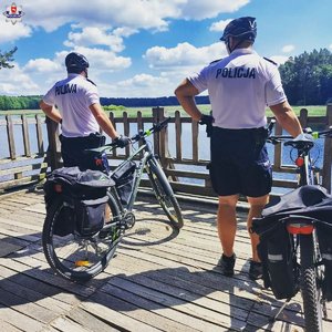 policjanci przy rowerach. W tle jezioro