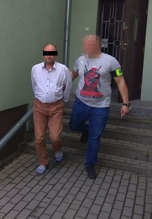 policjant doprowadza zatrzymanego