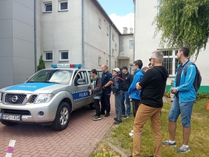 policjant podczas pogadanki z uczniami przy radiowozie