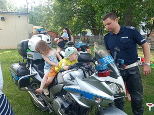 policjant z dziećmi siedzącymi na motocyklu