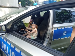 dziecko siedzące za kierownicą radiowozu