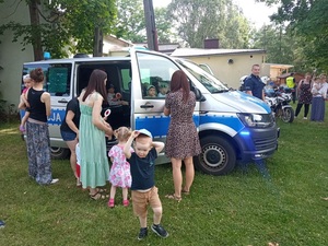 dzieci wraz z opiekunami oglądające radiowóz