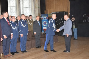 Komendant Wojewódzki z dowódcą uroczystości. W tle policjanci.