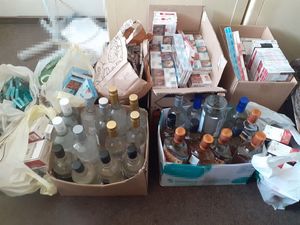 papierosy i alkohol bez polskich znaków skarbowych akcyzy stojące w pudełkach i leżące w reklamówkach