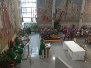 wnętrze kościoła. Księża celebrujący msze. Policjanci wraz ze sztandarem oraz wierni