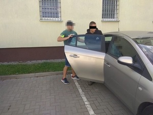 policjant doprowadza zatrzymanego