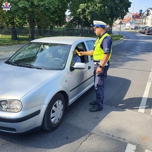 policjant przy samochodzie
policjant podaje alkometr kierowcy
dwóch policjantów jadących na motorach
policjant podczas kontroli pojazdu