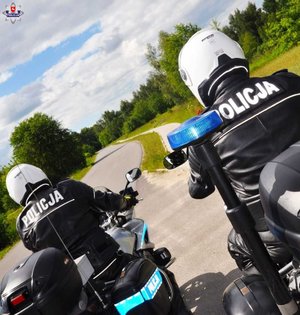 policjant przy samochodzie
policjant podaje alkometr kierowcy
dwóch policjantów jadących na motorach
policjant podczas kontroli pojazdu