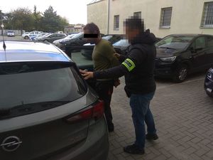 mężczyzna doprowadzany przez policjanta