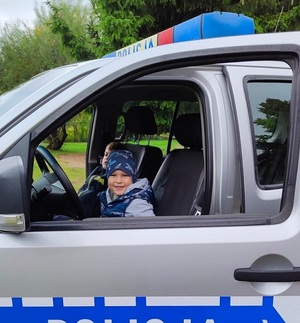 dzieci siedzące w radiowozie.