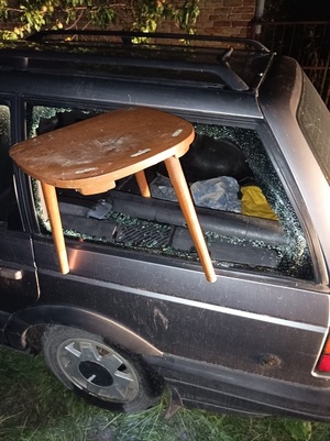 uszkodzony samochód z krzesłem włożonym w rozbitą szybę