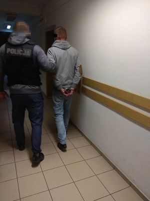 policjant doprowadza zatrzymanego