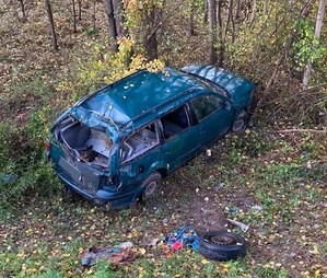 uszkodzony samochód stojący obok drzew