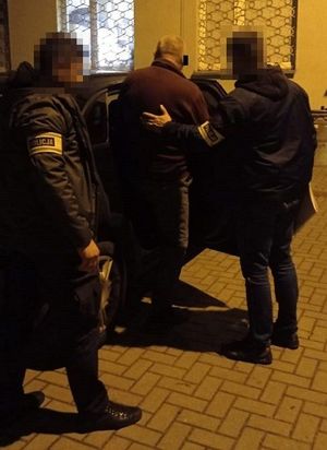 policjanci nieumundurowani doprowadzają zatrzymanego mężczyznę