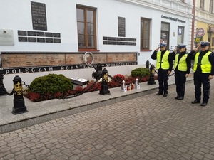 policjanci oddający honor przy pomniku na cześć poległych w czasie wojny działaczom ruchu oporu