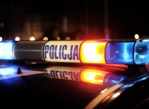 fragment radiowozu z włączonymi sygnałami świetlnymi