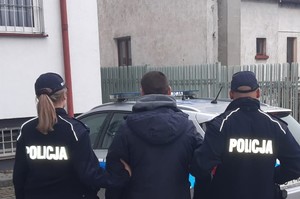 policjanci doprowadzają zatrzymanego