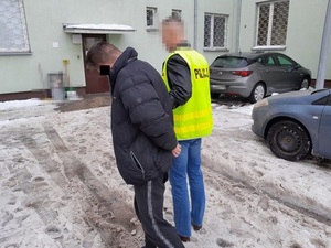 policjant doprowadza zatrzymanego