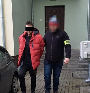 policjant doprowadza zatrzymanego